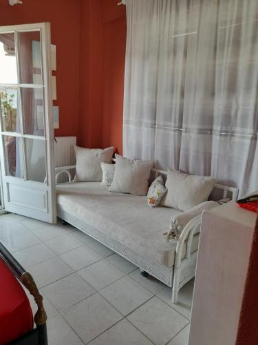 kanapę siedzącą w pokoju z oknem w obiekcie Cozy maisonette in Pefkochori Chalkidiki w mieście Pefkochori