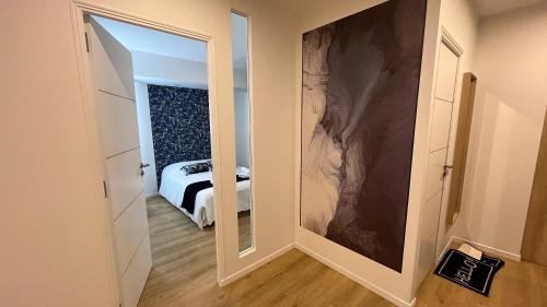 a hallway with a mirror and a bed in a room at Appartement Luxe Jaune in Saint Etienne