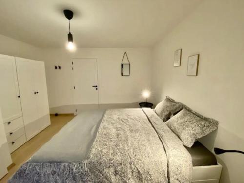 sypialnia z dużym łóżkiem i białymi szafkami w obiekcie City and Nature w Gandawie