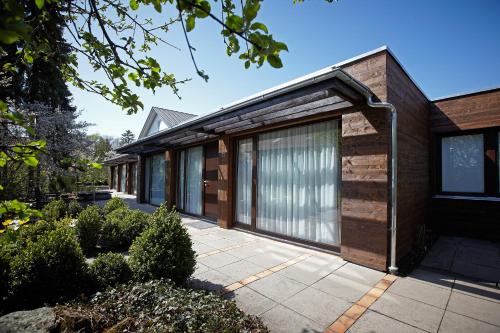 a house with a wooden facade with a patio at Hotel Klingelhöffer in Alsfeld