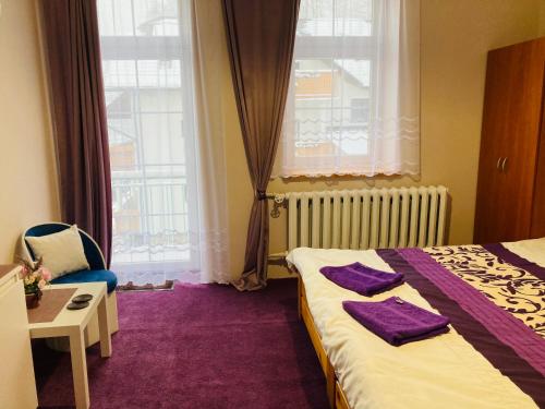 ein Schlafzimmer mit einem Bett, einem Stuhl und einem Fenster in der Unterkunft Dworek Ewunia in Wisła