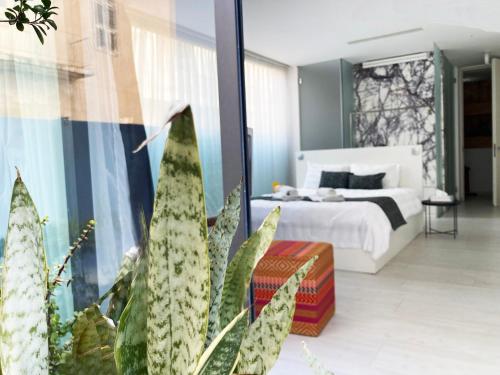 ラルナカにあるLokàl Boutique Hotelのベッドルーム1室(ベッド1台、植物付)