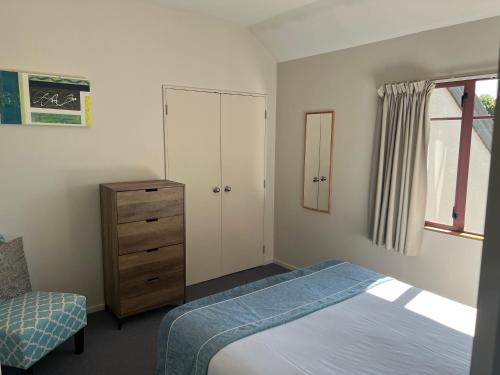 a bedroom with a bed and a cabinet and a dresser at Quality Inn Acapulco Taupo in Taupo