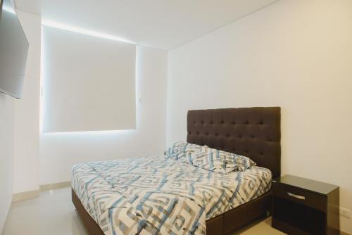 a small bedroom with a bed and a nightstand at Edificio Reserva del Mar, apartamentos 1618, 1614 y 1714 in Santa Marta
