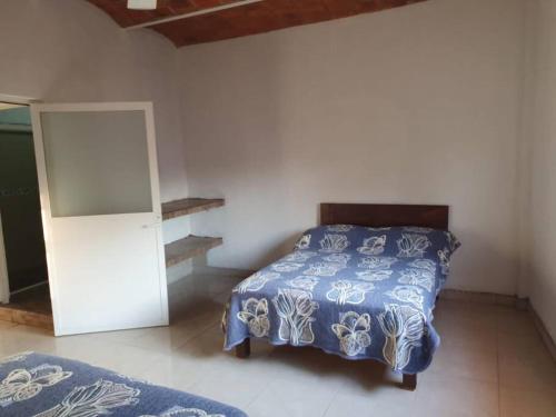 um quarto com uma cama com uma colcha azul e branca em C911 Casa 2 niveles y alberca privada em Peñita de Jaltemba