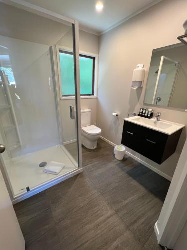 a bathroom with a shower and a toilet and a sink at Quality Inn Acapulco Taupo in Taupo