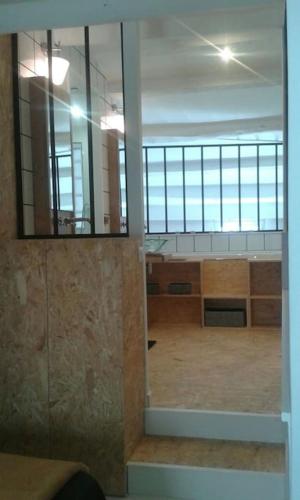 une chambre avec un grand miroir et une grande chambre avec une pièce dans l'établissement Ô p'tit LoFt du port de chat'Sâ, à Chaillevette