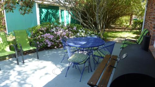 un patio con tavolo blu, sedie e fiori di GOLDEN DAYS DUPLEX Duplex a Jekyll Island