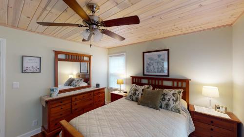 una camera da letto con un letto e un ventilatore a soffitto di CARRIED AWAY home a Jekyll Island