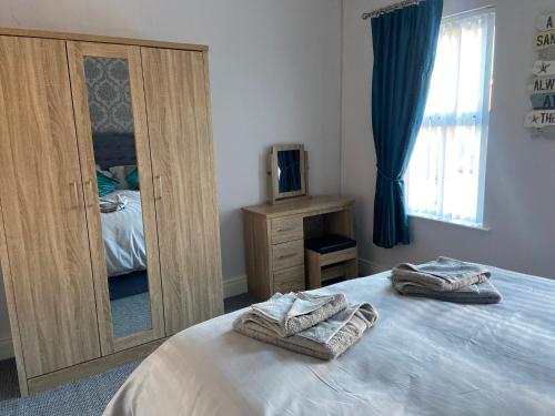 1 dormitorio con cama y espejo grande en Glenbann House, en Coleraine