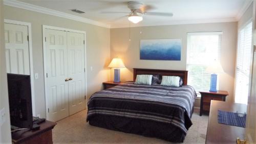 a bedroom with a bed and a ceiling fan at GUIDING LIGHT UNIT C - GROUNDFLOOR apts in Jekyll Island