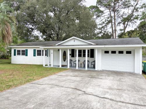 a white house with a car garage at HERON COTTAGE home in Jekyll Island