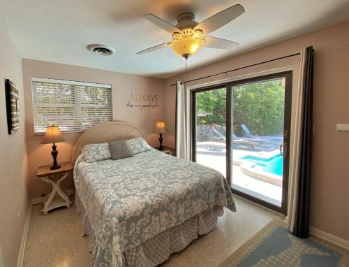 a bedroom with a bed and a sliding glass door at KISSES COTTAGE home in Jekyll Island