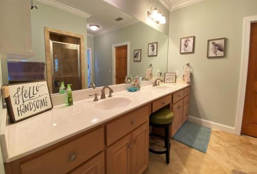 a bathroom with a sink and a large mirror at THE SALTY SOL home in Jekyll Island