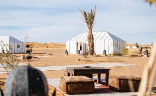 a picnic table in the middle of the desert at Khadija Desert Camp in Merzouga