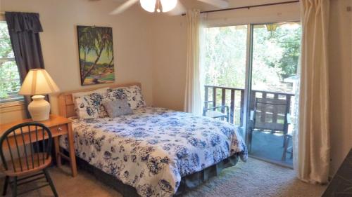 a bedroom with a bed and a table and a window at ARIEL EAST DUPLEX Duplex in Jekyll Island