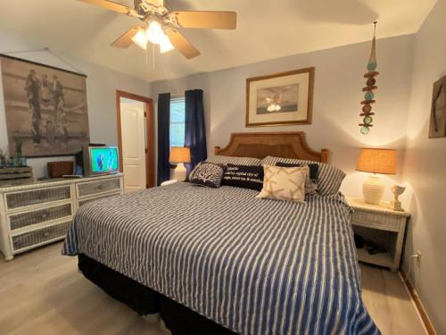 a bedroom with a bed and a ceiling fan at HOLLAND HOUSE DUPLEX Duplex in Jekyll Island