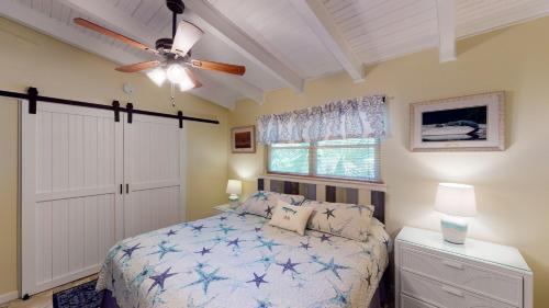 a bedroom with a bed and a ceiling fan at BARRONHAUS home in Jekyll Island