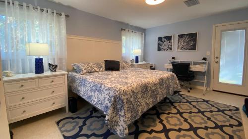 a bedroom with a bed and a desk with a laptop on it at CUDDLEFISH home in Jekyll Island