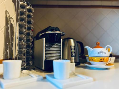 a kitchen counter with cups and a coffee maker at Appartamento tra Aeroporto DaVinci e Fiera di Roma in Fiumicino