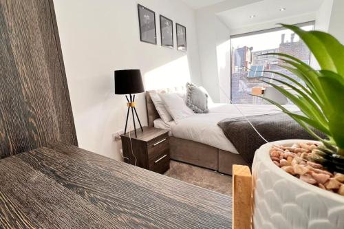 a bedroom with a bed and a potted plant at Luxury Penthouse in Merseyside, Waterfront in Liverpool