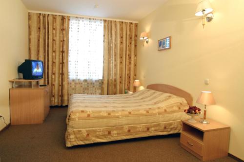 Un dormitorio con una cama grande y una ventana en Vodnik Club, en Dolgoprudny