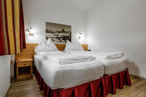 two beds sitting next to each other in a room at HOTEL B&B MARILENA in Arabba