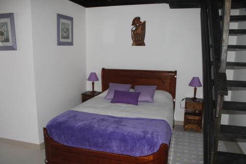a bedroom with a bed with purple sheets and purple pillows at Refugio no Campo - AL 1683 in Rapoula do Côa