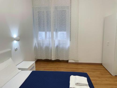 een witte kamer met een bed en een raam bij Nuovo Confortini Rooms in Verona
