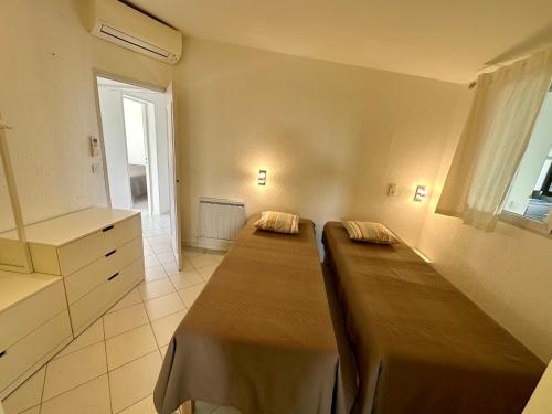 a bedroom with two beds and a window at Villa MahJong Piscine Vue Mer Clim 6 adultes et 2 enfants in Cavalaire-sur-Mer