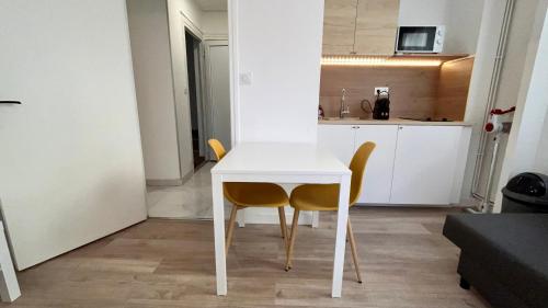 a white table and two chairs in a kitchen at Europole 1 Gare de Grenoble & Centre Ville in Grenoble