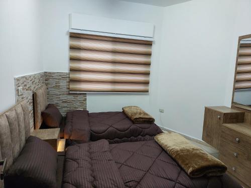 a bedroom with two beds with pillows on them at Cozy Home 2 in Amman