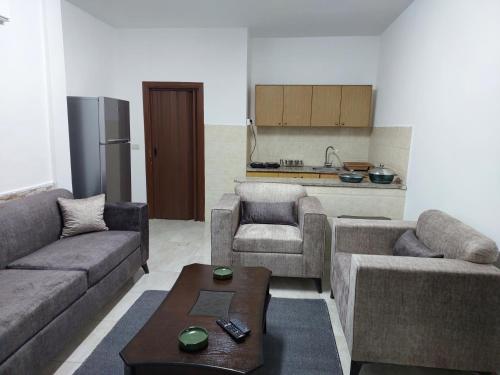 a living room with two couches and a kitchen at Cozy Home 2 in Amman