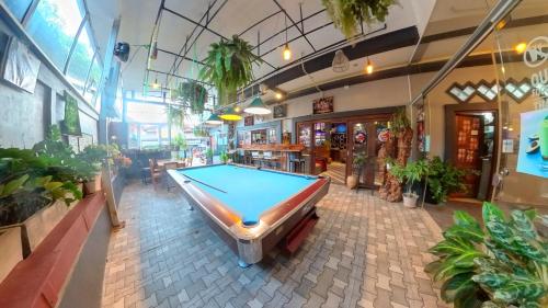a pool table in a room with plants at FARAWAY SUITES in Vang Vieng