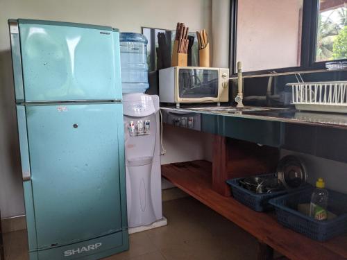 a kitchen with a green refrigerator and a microwave at Serendip Villa Holiday HomeTalalla Sri Lanka in Matara