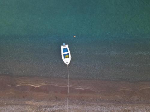 a boat sitting on the shore of the beach at Seashore Beachfront Villa in Lachania