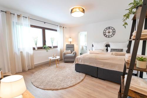 a bedroom with a large bed and a chair at INhome Design Studio für 2 - Küche - Parkplatz - Netflix in Crailsheim