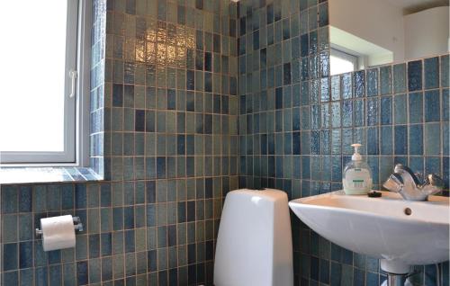 a bathroom with blue tiled walls and a sink at Beach Front Home In Hundested With Wifi in Hundested