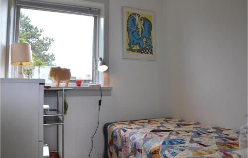 a bedroom with a bed and a cat sitting on a window at Beach Front Home In Hundested With Wifi in Hundested