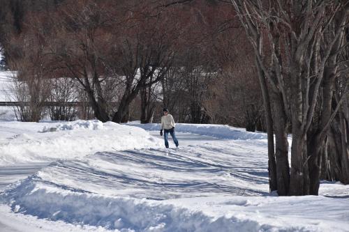 a man walking down a snow covered road at Chesa Sonnenuhr in Madulain