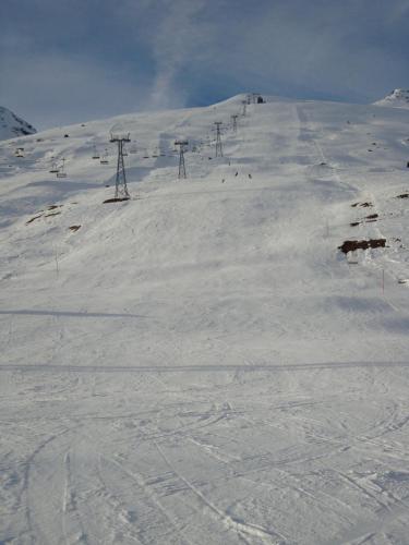 a snow covered ski slope with a ski lift at Chesa Sonnenuhr in Madulain
