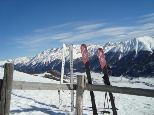 a pair of skis leaning against a fence in the snow at Chesa Sonnenuhr in Madulain