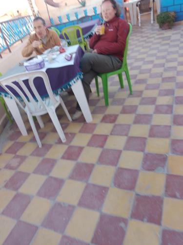 two older women sitting at a table in a restaurant at Auberge Restaurant Rooftop Tamazirt in Boumalne