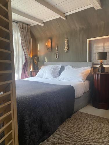 een slaapkamer met een groot bed en een raam bij De Schuilhoek Private Guesthouse in Blaricum