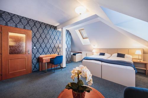 赫拉德茨－克拉洛韋的住宿－烏克拉羅偉伊利斯基酒店，酒店客房配有一张床铺和一张桌子。