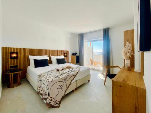 een slaapkamer met een bed en een raam met uitzicht bij Calistus Mykonos in Mykonos-stad