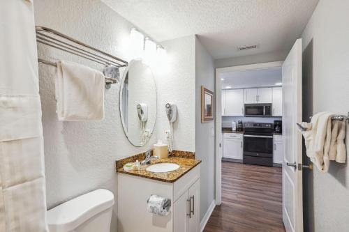 a bathroom with a sink and a counter with a mirror at Sunset Vistas 603W in St Pete Beach