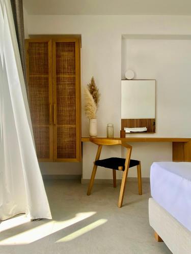 a room with a desk and a table with a mirror at Calistus Mykonos in Mýkonos City