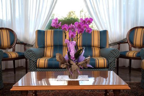 a vase of purple flowers sitting on a coffee table at Hotel Terme Abano Verdi in Abano Terme