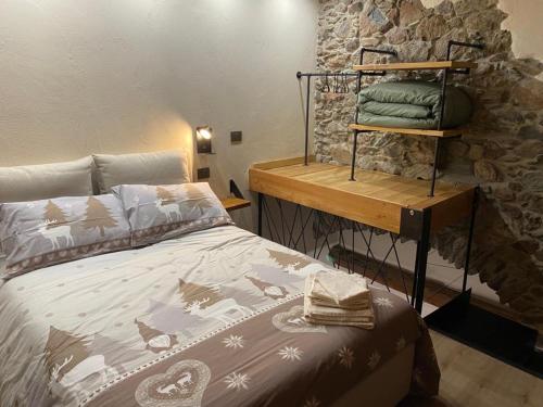 a bedroom with a bed and a stone wall at Chez Margot et Sophie in Torgnon